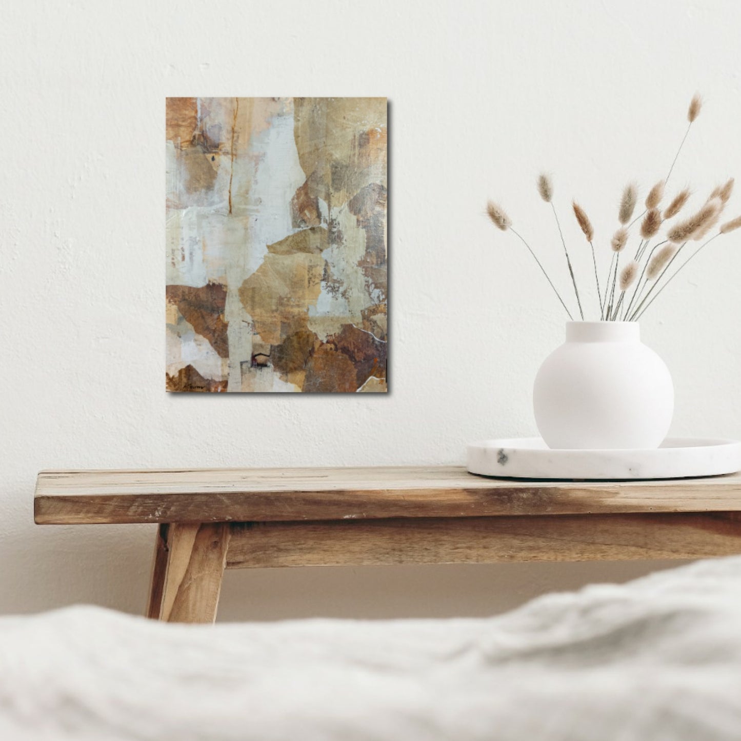 Abstract mixed media painting Woodland Falls displayed above a bed in a serene bedroom. The artwork features textured layers of earthy browns, warm sienna, soft creams, and muted whites, complementing the room’s natural and calming decor.