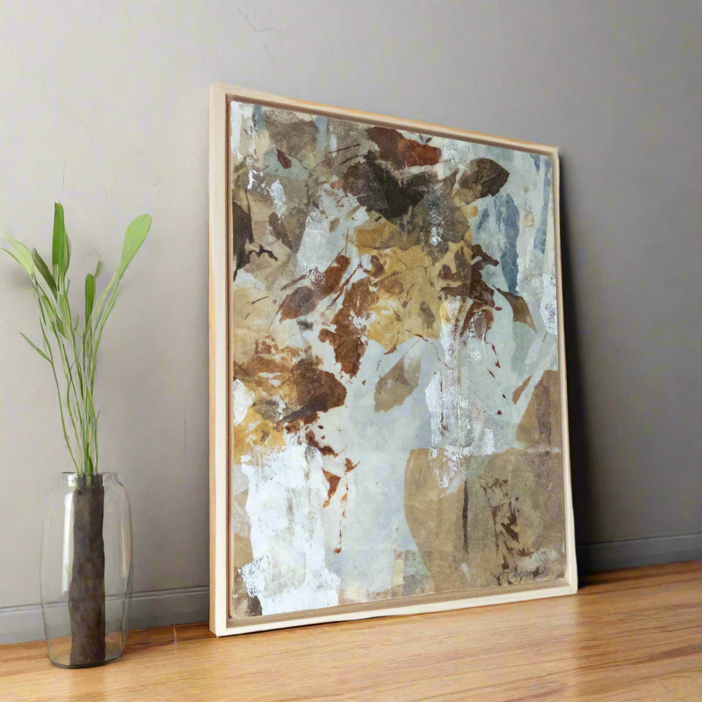 Abstract art piece with brown and blue tones in a wooden frame on a gray wall.