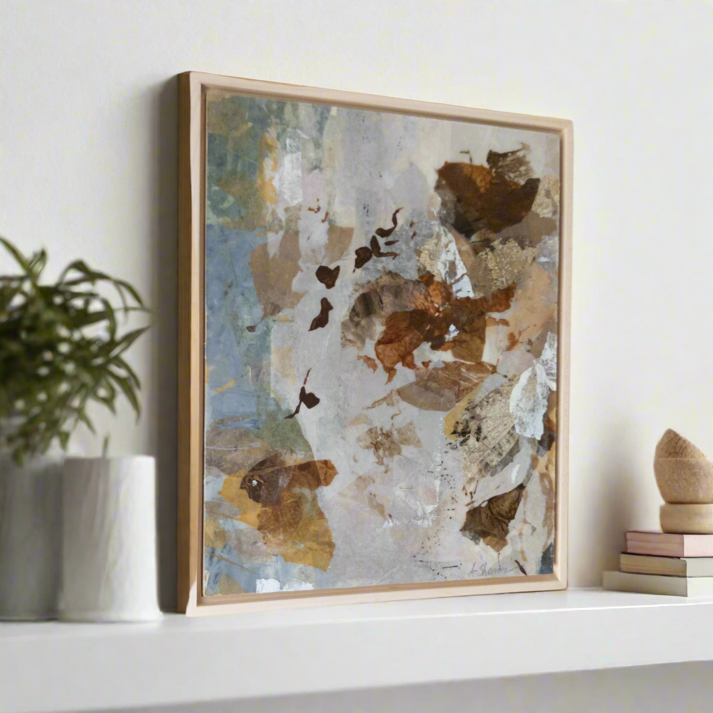 Framed abstract art piece on a shelf with decorative items