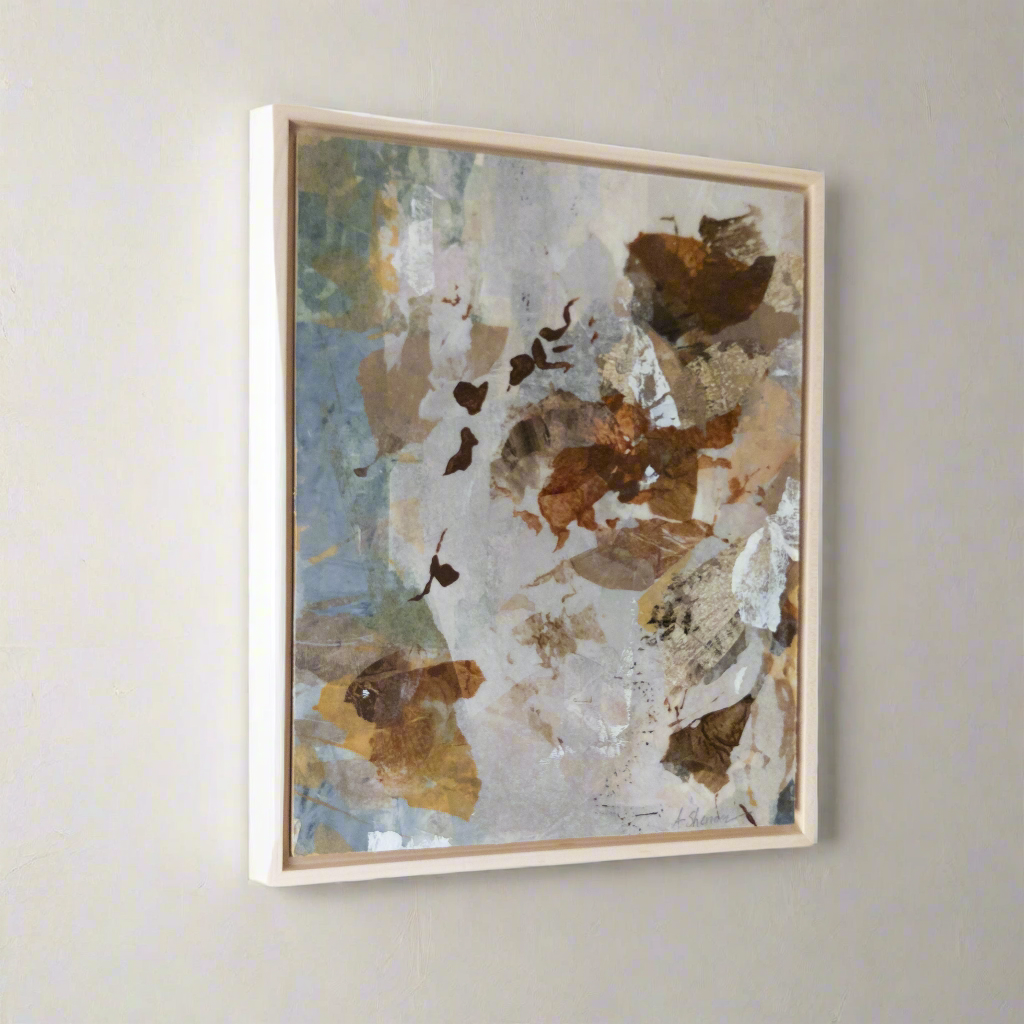 Abstract art piece with brown and blue tones in a wooden frame on a light gray wall.