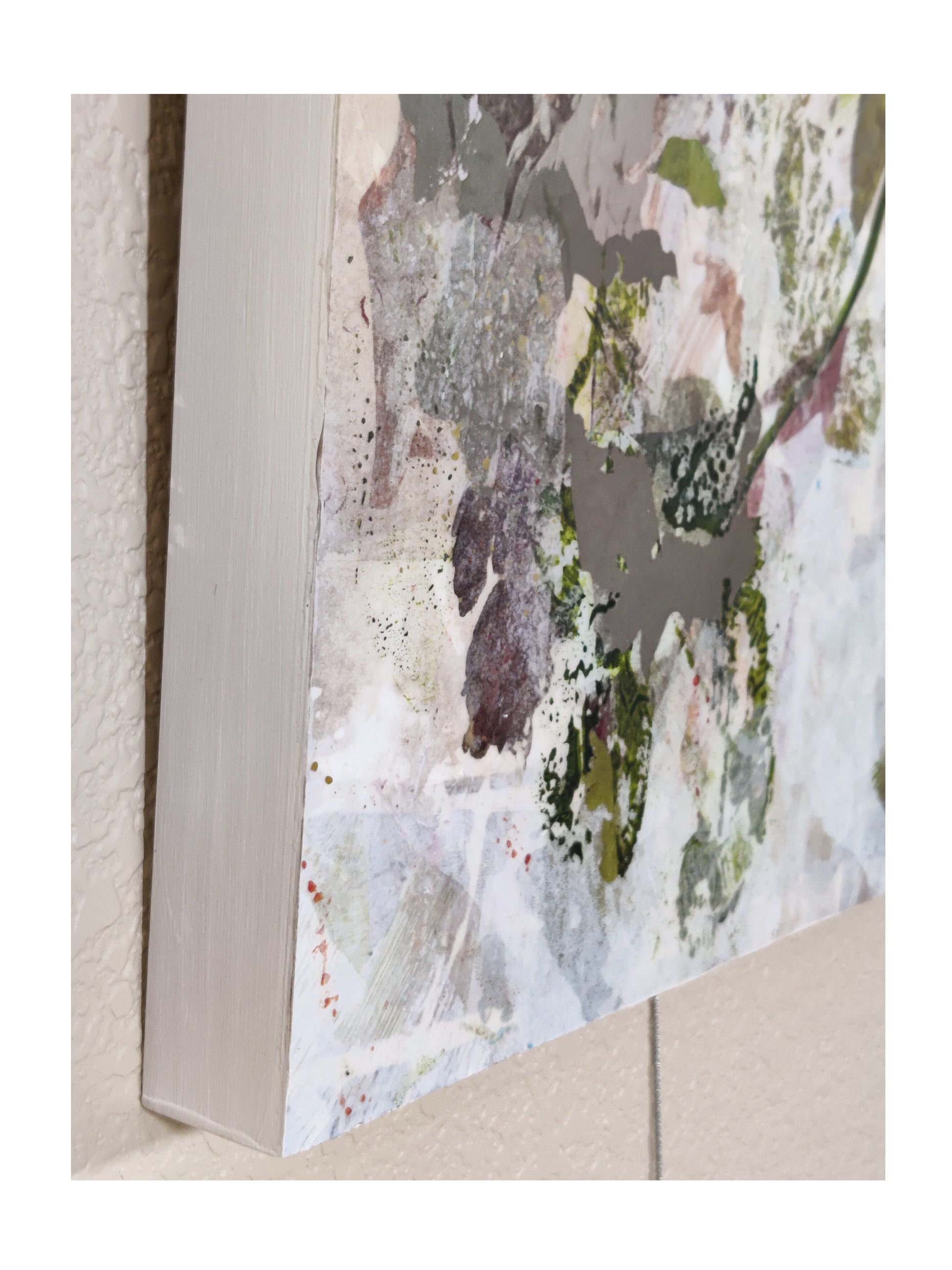 Abstract art piece with a textured frame on a textured wall.